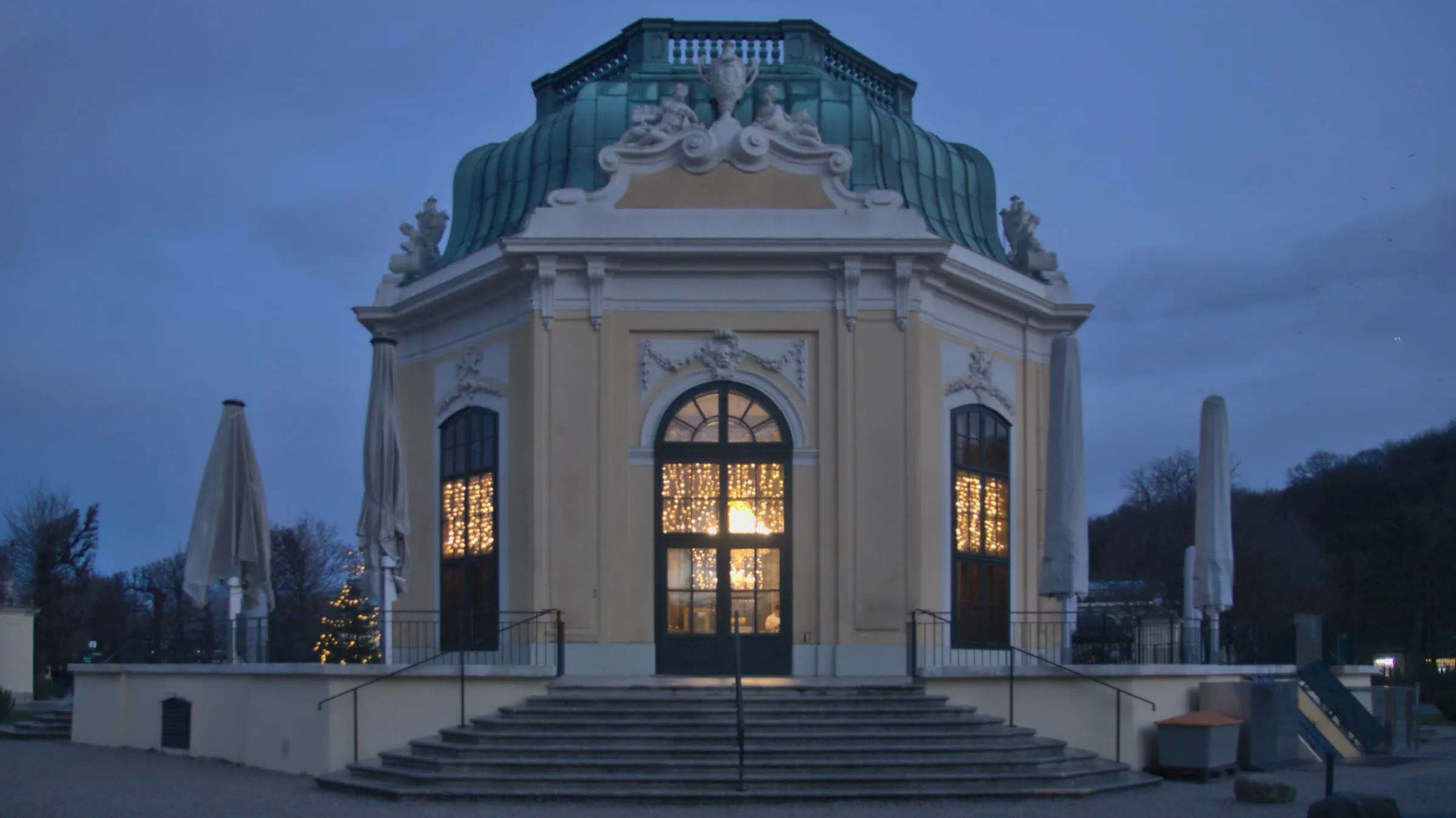 Der barocke Kaiserpavillon im Herzen des Tiergartens Schönbrunn in Wien in der Abenddämmerung, seine Fenster erleuchtet