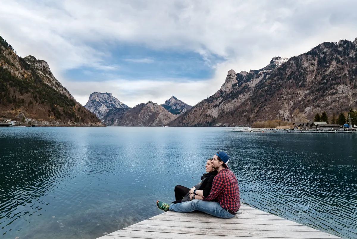 A couple on a jetty above an alpine lake in Austria